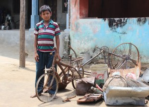 A boy with his charred bicycle